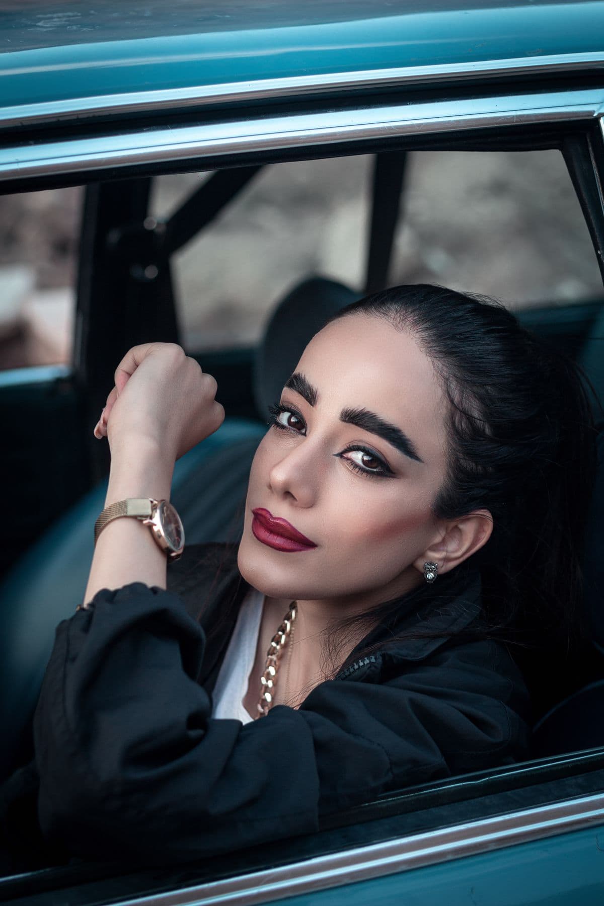 Woman with red lipstick leaning out of a car window